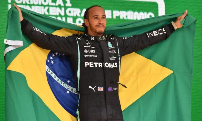 Piloto britânico abraça a bandeira brasileira e homenageia Ayrton Senna. Crédito: Divulgação