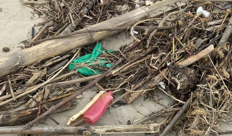 Os amontoados de sujeira se misturavam com a paisagem da praia