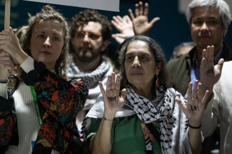 Tasneem Essop, diretora-executiva da rede de ONGs Climate Action Network, participa de manifestação nas negociações finais da COP29, em Baku, com os dizeres “pay up”, que significa “paguem”, escrito nas mãos (Foto: UN Climate Change - Kiara Worth)