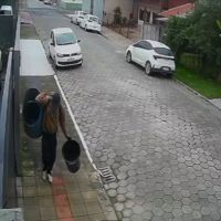 Câmeras de segurança flagram furto de latões de lixo em plena luz do dia