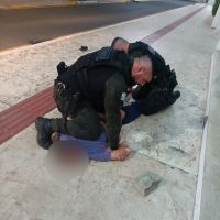 Homem em surto tenta quebrar vidraça de loja