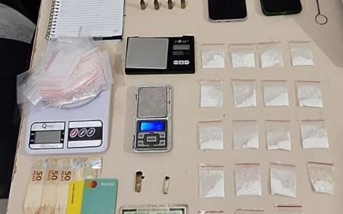 Legenda: Homem de 20 anos é preso em Itapema por tráfico e porte ilegal de munição; drogas e equipamentos foram apreendidos (Foto: Impresa do 31º BPM)